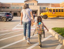 Mother walking child into school representing child custody during back to school season in San Antonio.